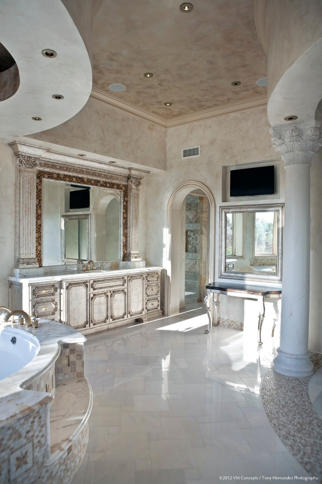 Свежая идея для дизайна: большая главная ванная комната в средиземноморском стиле с фасадами с выступающей филенкой, искусственно-состаренными фасадами, угловой ванной, душевой комнатой, раздельным унитазом, разноцветной плиткой, цементной плиткой, бежевыми стенами, полом из известняка, врезной раковиной, столешницей из кварцита, белым полом и душем с распашными дверями - отличное фото интерьера