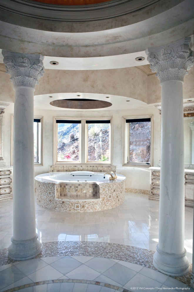Стильный дизайн: большая главная ванная комната в средиземноморском стиле с фасадами с выступающей филенкой, искусственно-состаренными фасадами, угловой ванной, душевой комнатой, раздельным унитазом, разноцветной плиткой, цементной плиткой, бежевыми стенами, полом из известняка, врезной раковиной, столешницей из кварцита, белым полом и душем с распашными дверями - последний тренд