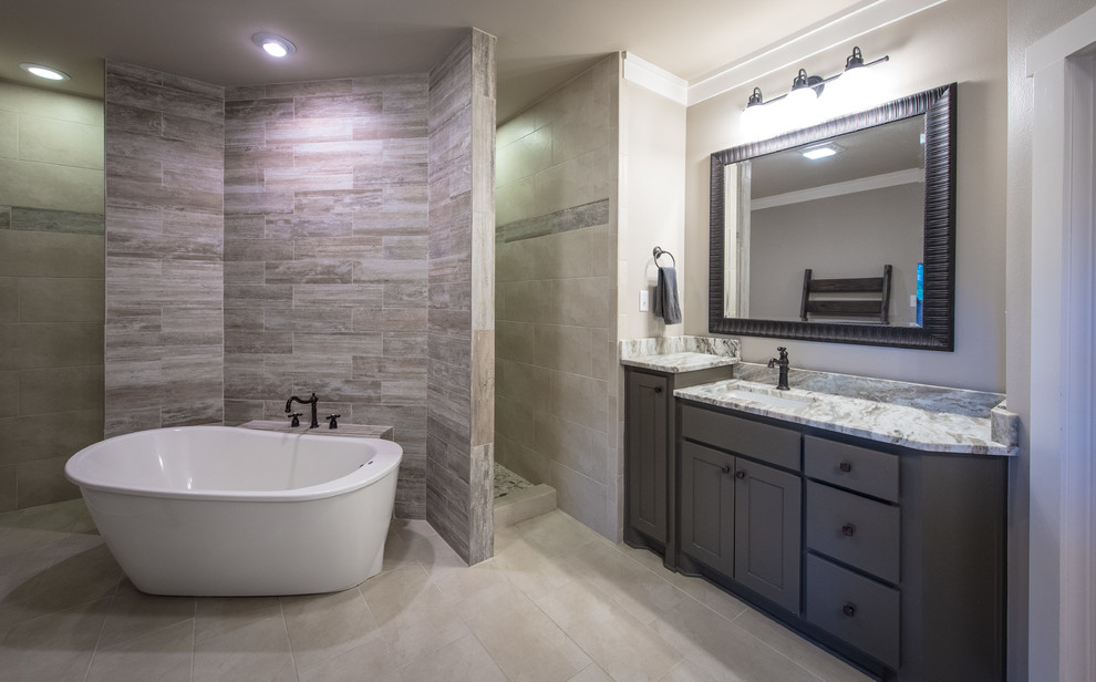 Large traditional ensuite bathroom in Little Rock with flat-panel cabinets, dark wood cabinets, a freestanding bath, a walk-in shower, a two-piece toilet, slate tiles, beige walls, slate flooring, a submerged sink, granite worktops and grey tiles.