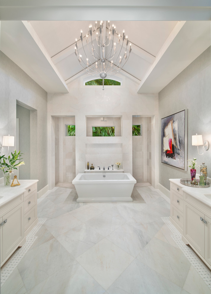 Diseño de cuarto de baño principal exótico grande con puertas de armario blancas, bañera exenta, suelo de baldosas de porcelana, encimera de mármol y ducha empotrada