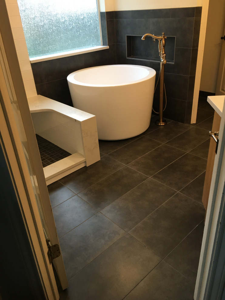 Inspiration for a medium sized contemporary ensuite bathroom in Austin with recessed-panel cabinets, medium wood cabinets, a japanese bath, a corner shower, a two-piece toilet, white tiles, ceramic tiles, white walls, porcelain flooring, a submerged sink, engineered stone worktops, black floors, a hinged door and white worktops.