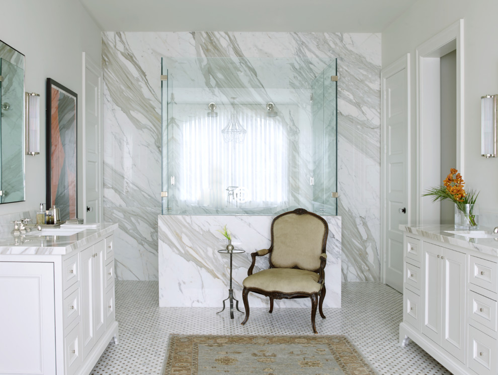 Inredning av ett klassiskt mycket stort en-suite badrum, med vita skåp, en dubbeldusch, vit kakel, marmorkakel, vita väggar, marmorgolv, ett undermonterad handfat, marmorbänkskiva, vitt golv, dusch med gångjärnsdörr och luckor med profilerade fronter