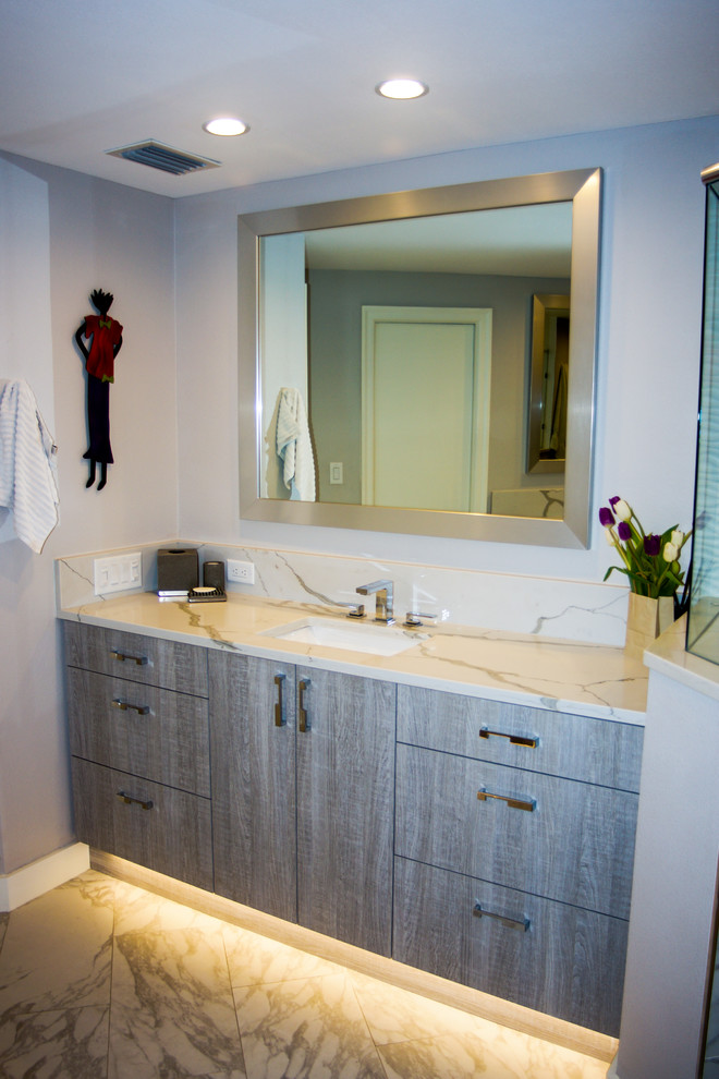 Diseño de cuarto de baño principal actual grande con armarios con paneles lisos, puertas de armario grises, ducha doble, baldosas y/o azulejos blancos, lavabo encastrado y encimera de cuarzo compacto
