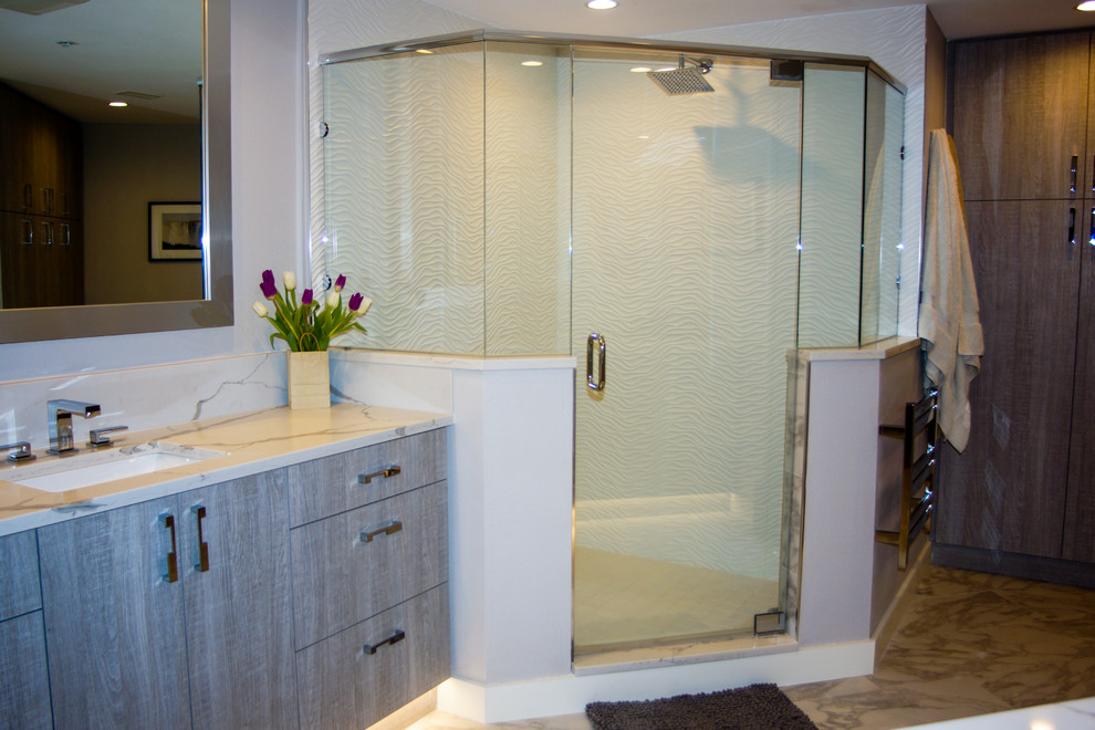 Modelo de cuarto de baño principal contemporáneo grande con armarios con paneles lisos, puertas de armario grises, ducha doble, baldosas y/o azulejos blancos, lavabo encastrado y encimera de cuarzo compacto