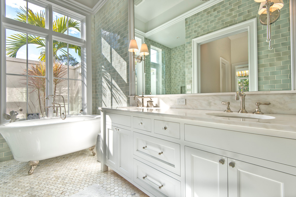 Klassisk inredning av ett mellanstort en-suite badrum, med ett badkar med tassar, en dusch i en alkov, en toalettstol med separat cisternkåpa, grön kakel, keramikplattor, beige väggar, mosaikgolv, ett undermonterad handfat, marmorbänkskiva, vita skåp och luckor med infälld panel