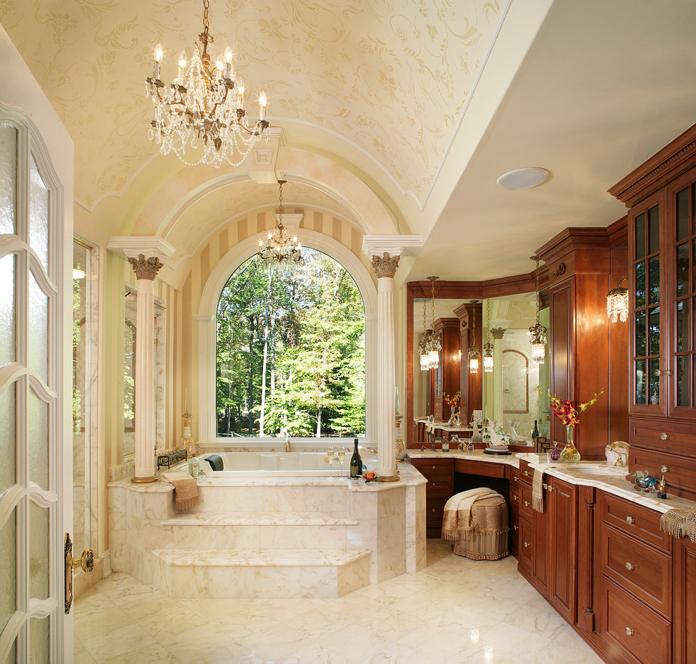 This is an example of a classic bathroom in New York with marble worktops, a submerged sink, recessed-panel cabinets, medium wood cabinets, a built-in bath, a walk-in shower, beige tiles and beige walls.