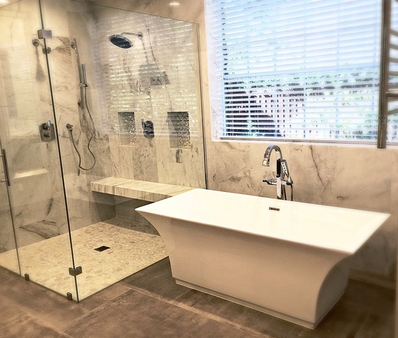 Photo of a large traditional ensuite bathroom in Houston with raised-panel cabinets, dark wood cabinets, a freestanding bath, a double shower, a one-piece toilet, grey tiles, stone tiles, grey walls, ceramic flooring, a vessel sink and marble worktops.