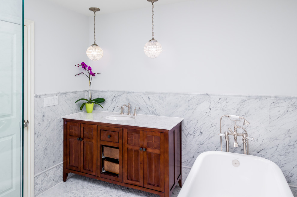 Inspiration för klassiska badrum, med ett undermonterad handfat, skåp i mörkt trä, ett fristående badkar, vit kakel, vita väggar och luckor med infälld panel