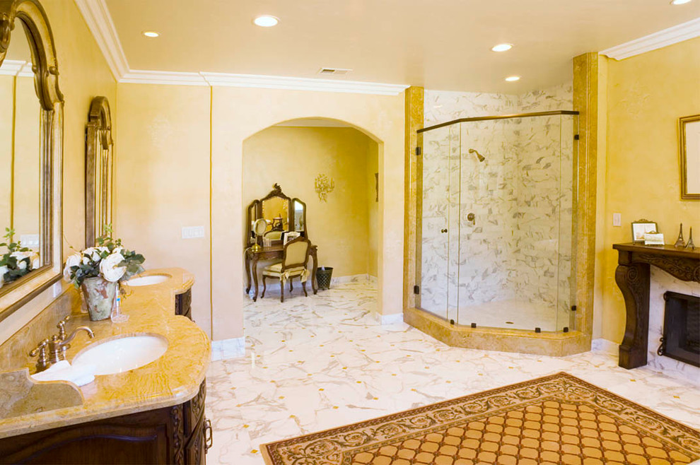 На фото: главная ванная комната в классическом стиле с врезной раковиной, фасадами островного типа, фасадами цвета дерева среднего тона, мраморной столешницей, отдельно стоящей ванной, угловым душем и мраморным полом