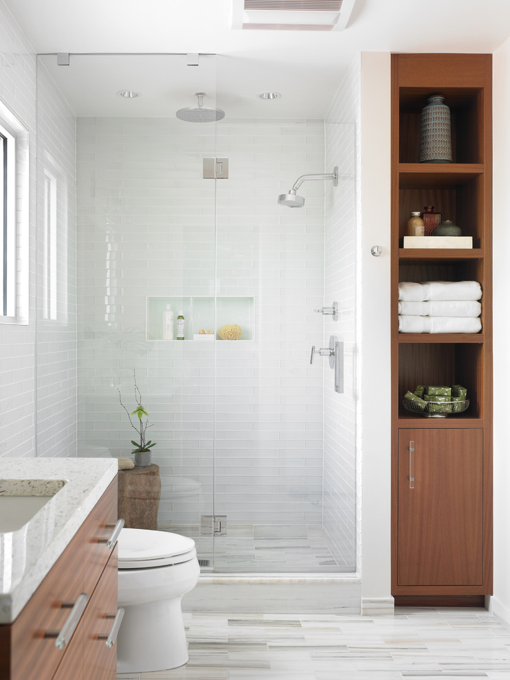 Idée de décoration pour une salle de bain principale minimaliste en bois brun de taille moyenne avec un lavabo encastré, un placard à porte plane, un carrelage blanc, un carrelage en pâte de verre, un sol en marbre et un mur blanc.