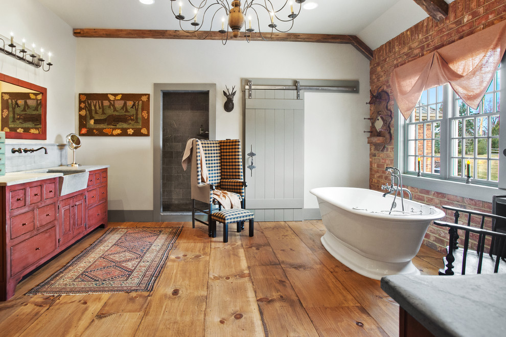 Rustikales Badezimmer En Suite mit weißer Wandfarbe, roten Schränken, freistehender Badewanne, braunem Holzboden und Kassettenfronten in Sonstige