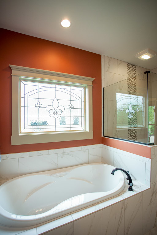 Inredning av ett klassiskt mellanstort en-suite badrum, med luckor med lamellpanel, skåp i mörkt trä, ett platsbyggt badkar, en dusch i en alkov, stenkakel, orange väggar, marmorgolv, ett undermonterad handfat och granitbänkskiva