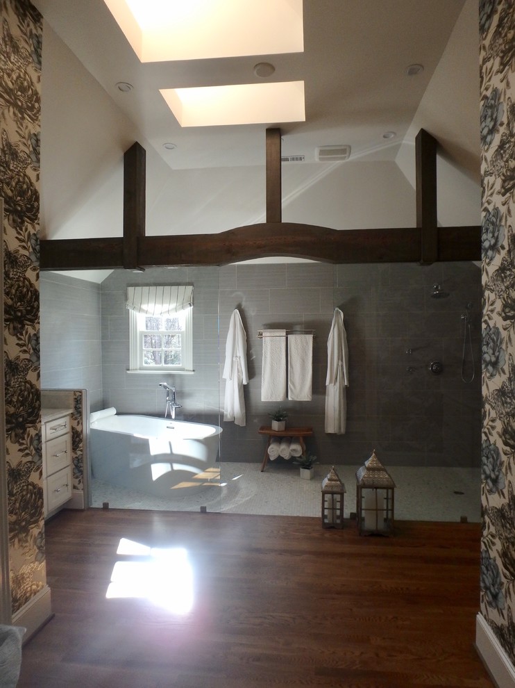 Inredning av ett modernt mellanstort en-suite badrum, med skåp i shakerstil, vita skåp, ett fristående badkar, våtrum, en toalettstol med hel cisternkåpa, grå kakel, mosaik, ett undermonterad handfat, marmorbänkskiva, mellanmörkt trägolv, grå väggar och brunt golv