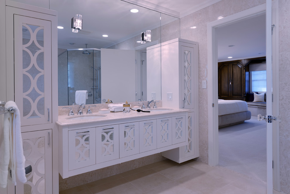 На фото: главная ванная комната среднего размера в современном стиле с фасадами островного типа, белыми фасадами, накладной ванной, угловым душем, раздельным унитазом, бежевой плиткой, каменной плиткой, бежевыми стенами, мраморным полом, врезной раковиной и мраморной столешницей с