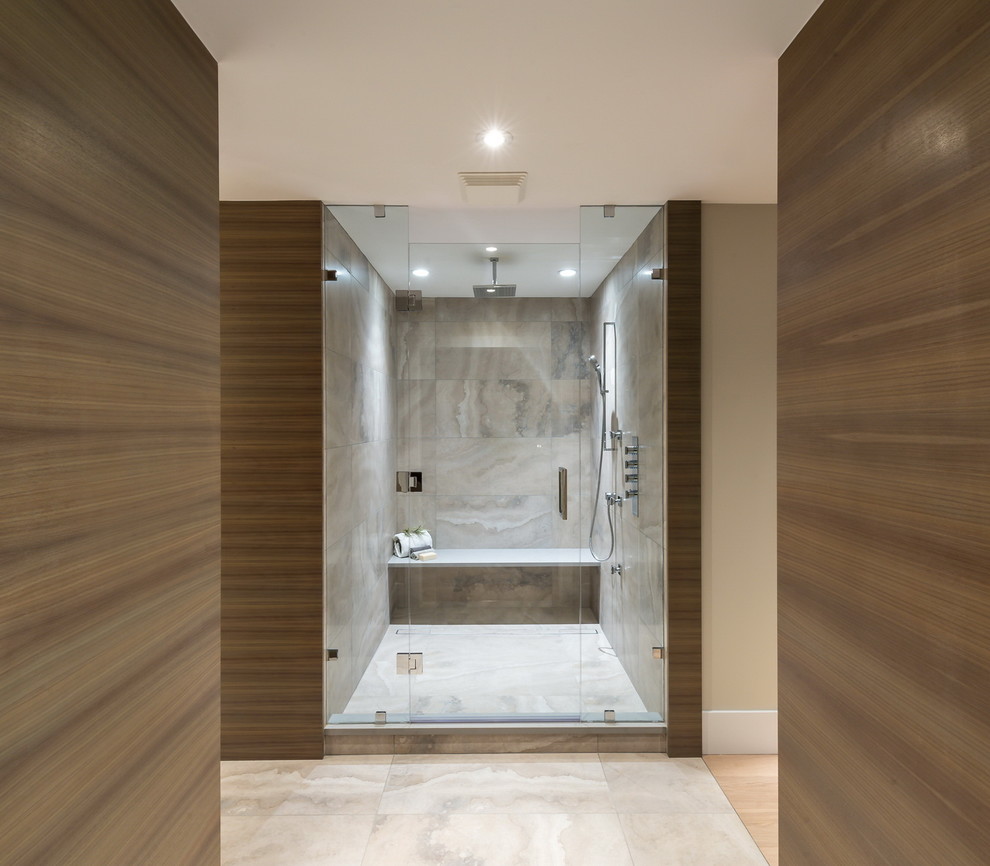 This is an example of a large contemporary ensuite bathroom in Vancouver with flat-panel cabinets, light wood cabinets, a freestanding bath, an alcove shower, a one-piece toilet, beige tiles, stone tiles, beige walls, marble flooring, a vessel sink and solid surface worktops.
