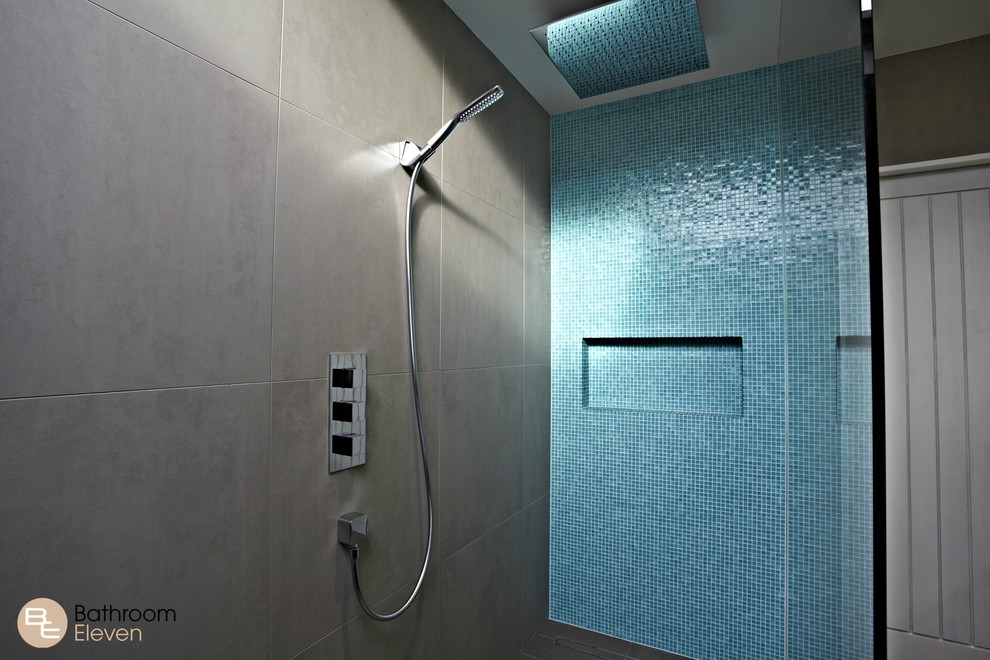 Inspiration för ett litet funkis en-suite badrum, med bruna skåp, en öppen dusch, blå kakel, grå väggar, cementgolv, mosaik, ett nedsänkt handfat, en vägghängd toalettstol, bänkskiva i akrylsten, grått golv, med dusch som är öppen och släta luckor
