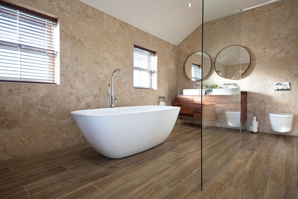 Immagine di una stanza da bagno costiera con piastrelle di pietra calcarea e pavimento in gres porcellanato