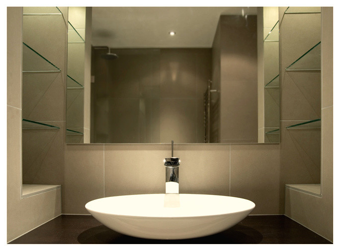 This is an example of a medium sized contemporary ensuite bathroom in London with glass-front cabinets, grey cabinets, a walk-in shower, a wall mounted toilet, grey tiles, porcelain tiles, grey walls, porcelain flooring, a pedestal sink, wooden worktops, grey floors and an open shower.