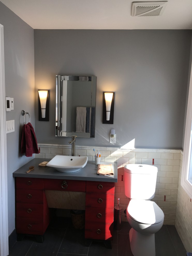 Идея дизайна: главная ванная комната среднего размера в стиле фьюжн с фасадами островного типа, красными фасадами, угловым душем, раздельным унитазом, серой плиткой, плиткой кабанчик, серыми стенами, полом из керамогранита, настольной раковиной и столешницей из искусственного камня