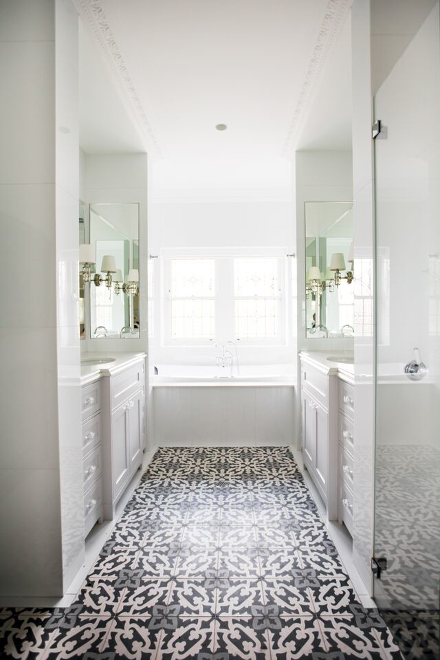 На фото: большая главная ванная комната в современном стиле с фасадами в стиле шейкер, накладной ванной, душем в нише, унитазом-моноблоком, белыми стенами, полом из керамической плитки, врезной раковиной, столешницей из искусственного кварца, белыми фасадами, белой плиткой, мраморной плиткой, серым полом и душем с распашными дверями