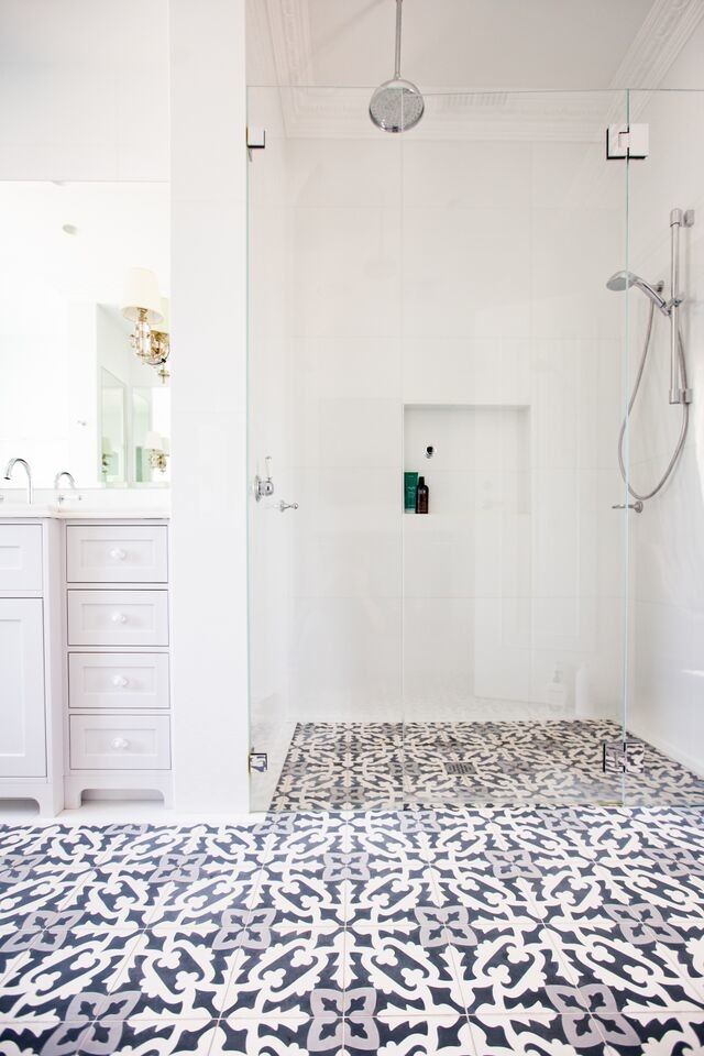 На фото: большая главная ванная комната в стиле модернизм с фасадами в стиле шейкер, накладной ванной, душем в нише, унитазом-моноблоком, белыми стенами, врезной раковиной, столешницей из искусственного кварца, белыми фасадами, белой плиткой, полом из цементной плитки, серым полом, душем с распашными дверями и мраморной плиткой с