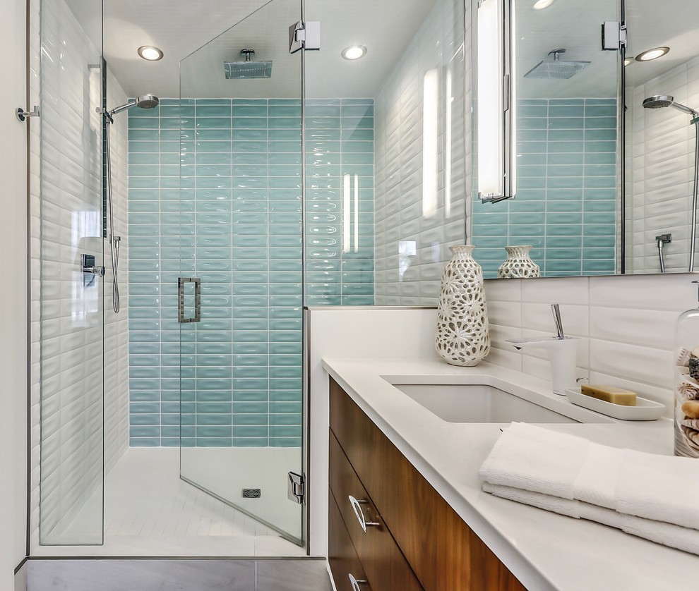 カルガリーにある高級な中くらいなミッドセンチュリースタイルのおしゃれなバスルーム (浴槽なし) (アルコーブ型シャワー、セラミックタイル、白い壁、磁器タイルの床、青いタイル、白いタイル、アンダーカウンター洗面器、クオーツストーンの洗面台、開き戸のシャワー、フラットパネル扉のキャビネット、濃色木目調キャビネット、グレーの床) の写真