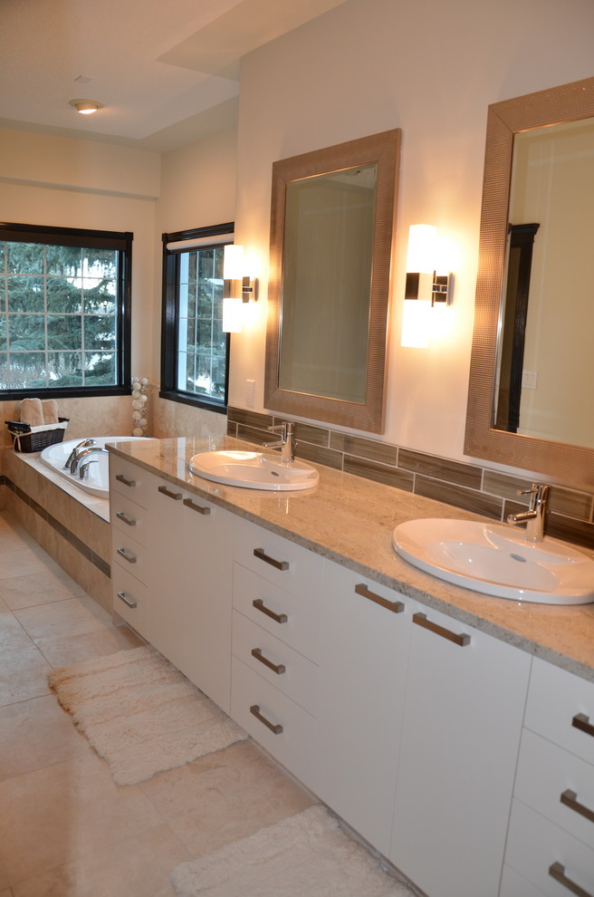 Idéer för att renovera ett stort funkis en-suite badrum, med släta luckor, vita skåp, ett platsbyggt badkar, en dusch i en alkov, en bidé, beige kakel, stenkakel, vita väggar, skiffergolv, ett nedsänkt handfat och granitbänkskiva