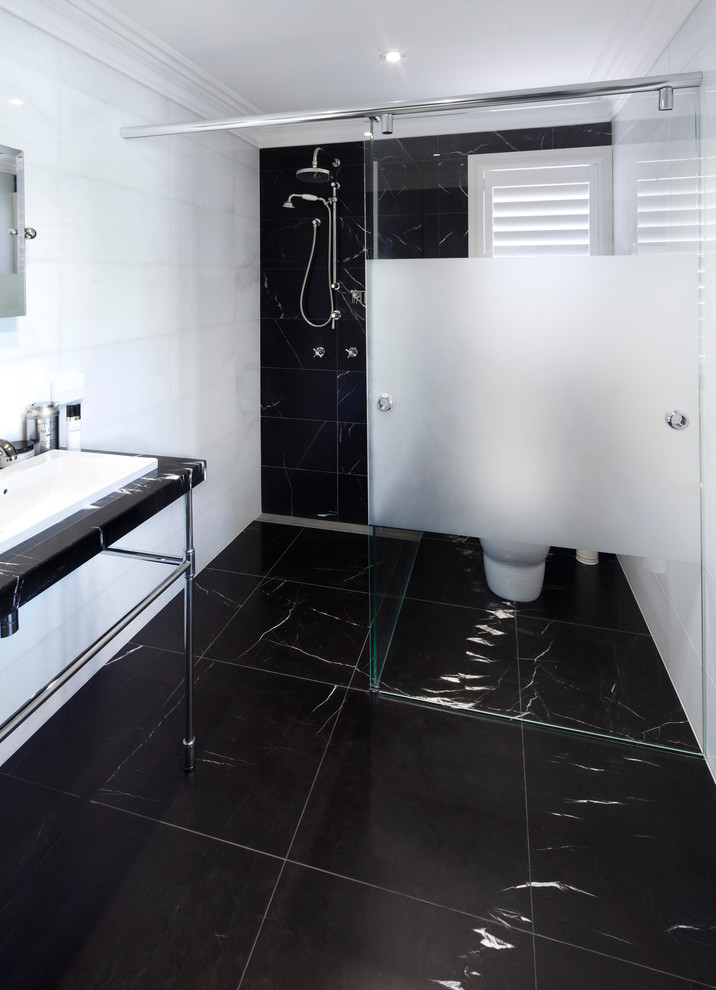 Idée de décoration pour une grande salle de bain principale design avec une baignoire indépendante, un espace douche bain, WC séparés, un carrelage noir, un carrelage noir et blanc, un carrelage blanc, un mur blanc, un sol en marbre, un plan vasque, un sol noir et une cabine de douche à porte battante.