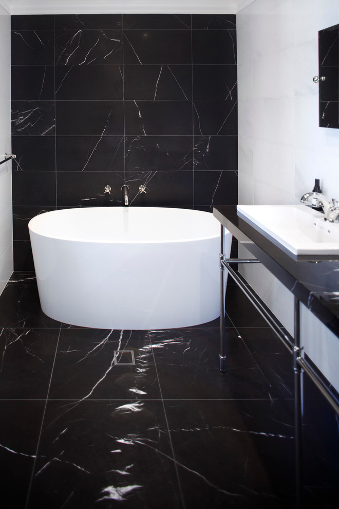 シドニーにあるラグジュアリーな広いコンテンポラリースタイルのおしゃれなマスターバスルーム (置き型浴槽、洗い場付きシャワー、黒いタイル、モノトーンのタイル、白いタイル、大理石の床、コンソール型シンク、黒い床、開き戸のシャワー) の写真