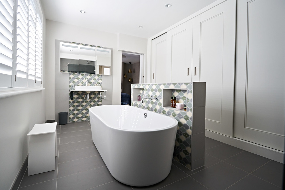 Medium sized classic ensuite wet room bathroom in Sussex with shaker cabinets, white cabinets, a freestanding bath, blue tiles, cement tiles, white walls, ceramic flooring, a pedestal sink, grey floors and an open shower.