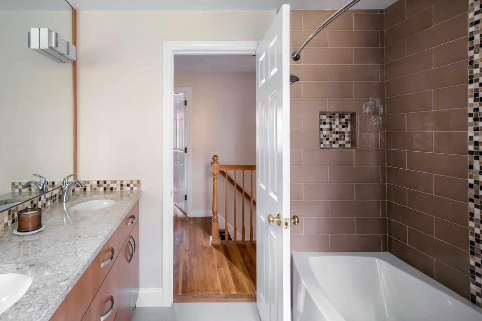 Photo of a traditional shower room bathroom in Boston with flat-panel cabinets, light wood cabinets, an alcove bath, a shower/bath combination, brown tiles, metro tiles, beige walls, light hardwood flooring, a submerged sink and granite worktops.
