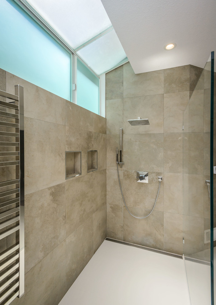 Inspiration for a large modern ensuite bathroom in San Francisco with an integrated sink, flat-panel cabinets, medium wood cabinets, solid surface worktops, a freestanding bath, a built-in shower, a wall mounted toilet, beige tiles, stone tiles and beige walls.