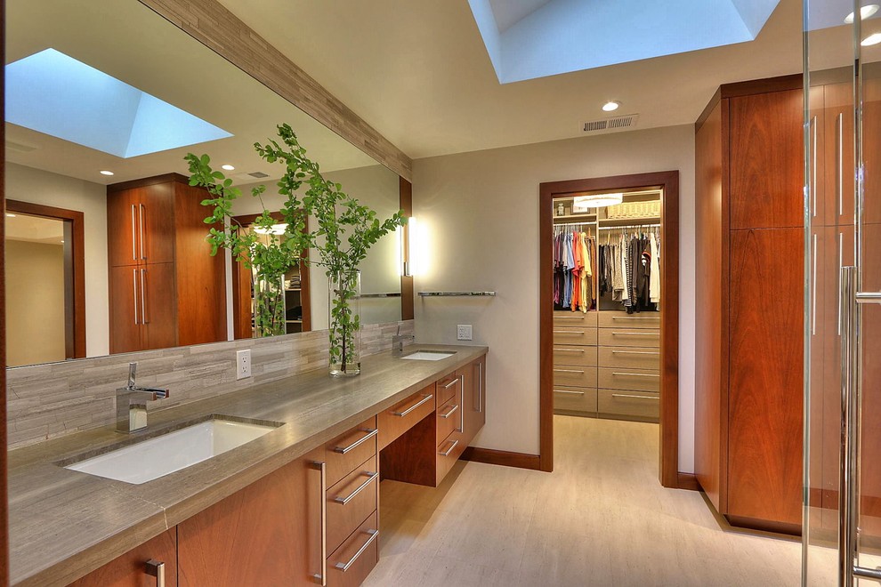 Foto de cuarto de baño principal actual grande con armarios con paneles lisos, puertas de armario de madera oscura, paredes beige y lavabo bajoencimera