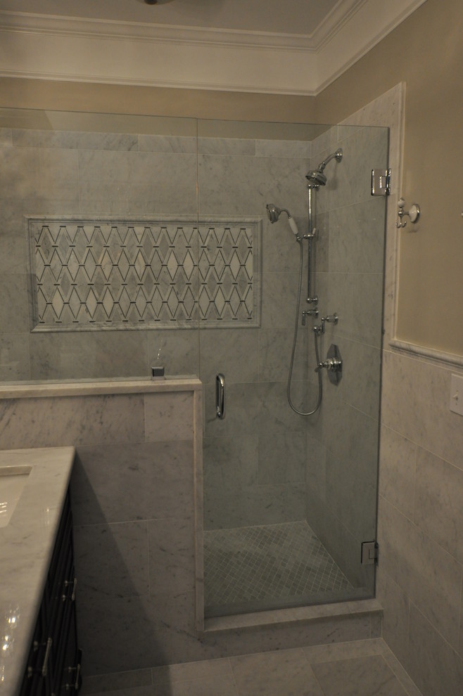 Стильный дизайн: большая главная ванная комната в классическом стиле с фасадами с выступающей филенкой, черными фасадами, отдельно стоящей ванной, душем в нише, унитазом-моноблоком, серой плиткой, белой плиткой, каменной плиткой, серыми стенами, мраморным полом, врезной раковиной и мраморной столешницей - последний тренд