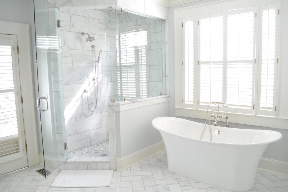 Пример оригинального дизайна: большая главная ванная комната в классическом стиле с фасадами с выступающей филенкой, белыми фасадами, отдельно стоящей ванной, раздельным унитазом, белой плиткой, серыми стенами, мраморным полом, врезной раковиной, мраморной столешницей и угловым душем