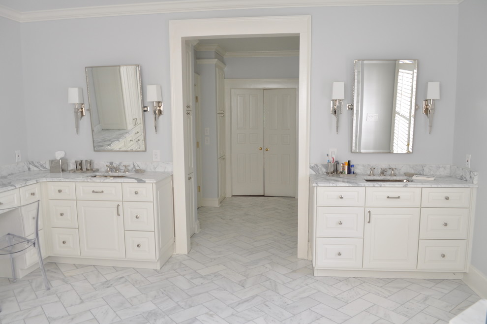 Foto på ett stort vintage badrum, med ett undermonterad handfat, luckor med upphöjd panel, vita skåp, marmorbänkskiva, ett fristående badkar, vit kakel, grå väggar, marmorgolv och en toalettstol med separat cisternkåpa