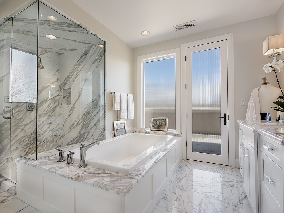 Idéer för att renovera ett mellanstort vintage en-suite badrum, med ett undermonterad handfat, släta luckor, vita skåp, marmorbänkskiva, ett platsbyggt badkar, vit kakel, stenkakel och marmorgolv