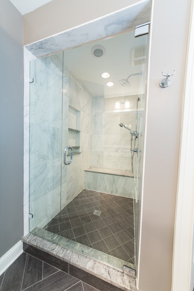 Inredning av ett klassiskt mellanstort grå grått en-suite badrum, med ett undermonterad handfat, luckor med upphöjd panel, vita skåp, granitbänkskiva, en dusch i en alkov, en toalettstol med separat cisternkåpa, grå kakel, porslinskakel, grå väggar, klinkergolv i porslin, grått golv och dusch med gångjärnsdörr