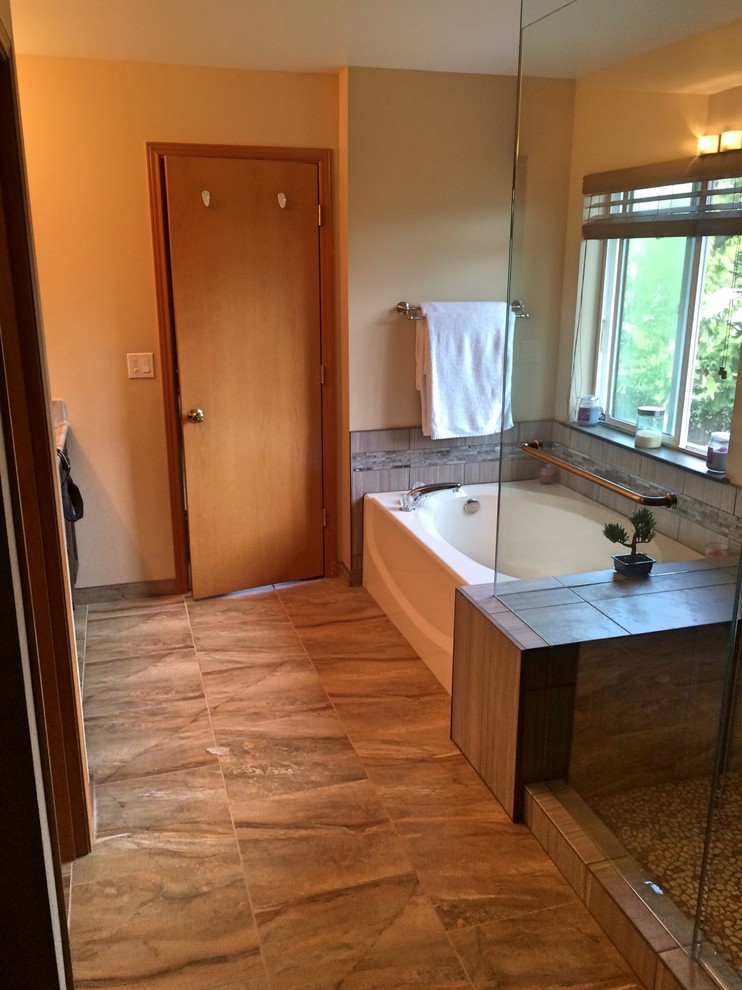 Bild på ett litet en-suite badrum, med bruna skåp, en toalettstol med separat cisternkåpa, brun kakel, cementkakel, klinkergolv i keramik, ett undermonterad handfat och bänkskiva i kvartsit
