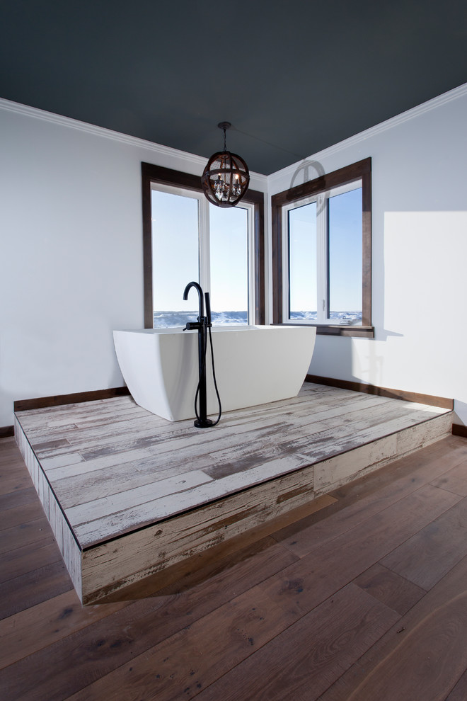 На фото: большая главная ванная комната в восточном стиле с отдельно стоящей ванной, белыми стенами, темным паркетным полом и коричневым полом