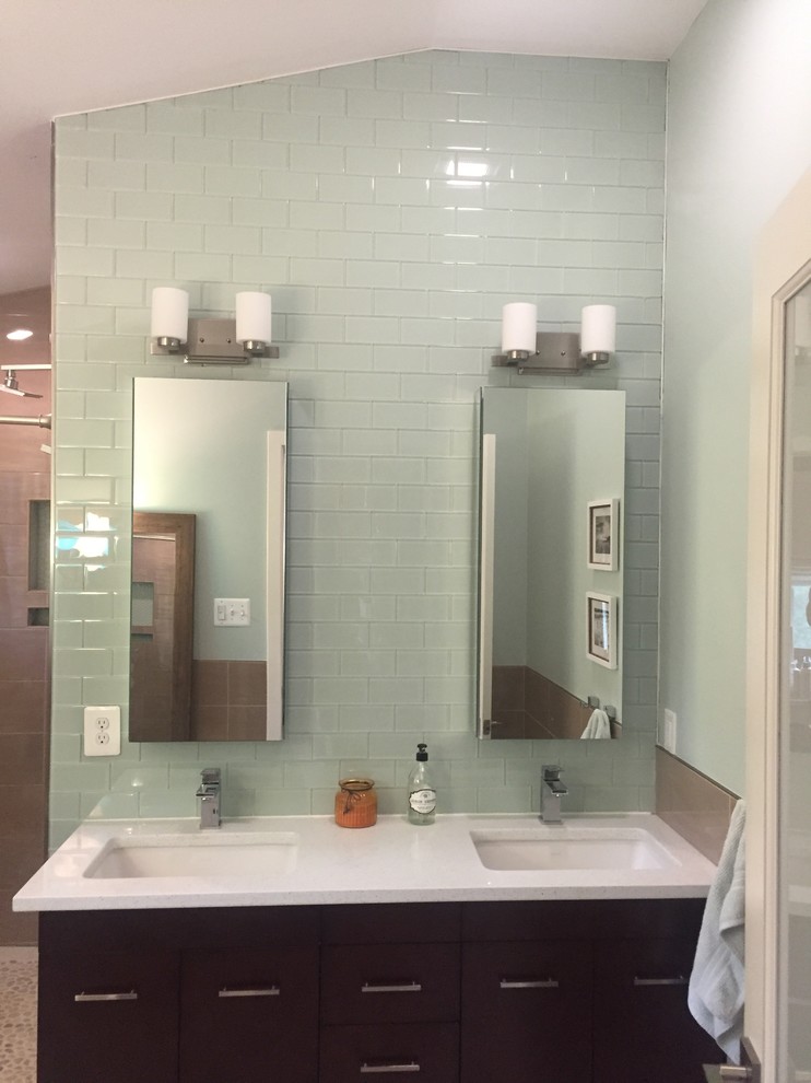 Идея дизайна: ванная комната среднего размера в современном стиле с плоскими фасадами, темными деревянными фасадами, душем в нише, зеленой плиткой, стеклянной плиткой, белыми стенами, душевой кабиной, врезной раковиной, столешницей из искусственного кварца и белой столешницей