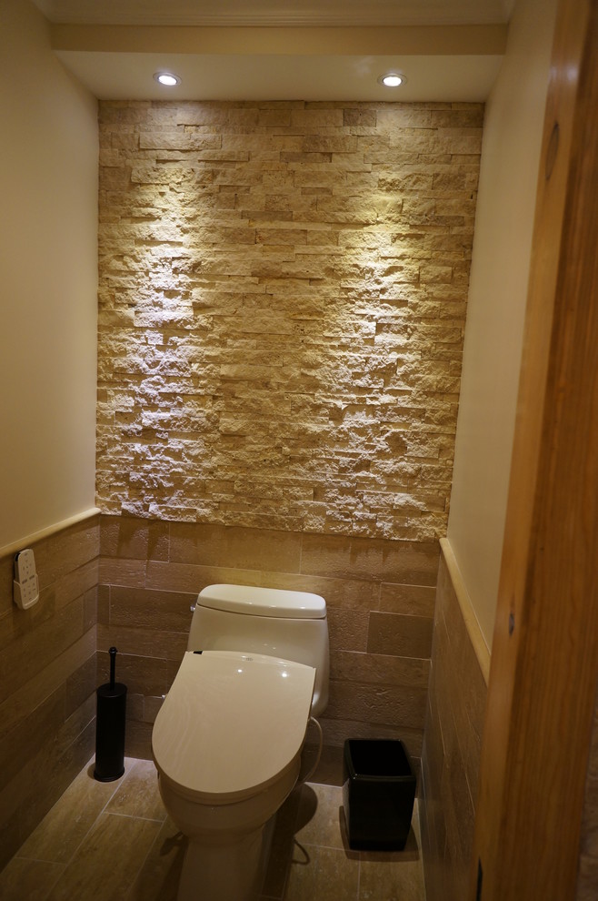 Exemple d'un WC et toilettes méditerranéen de taille moyenne avec un carrelage de pierre, un sol en carrelage de porcelaine et un lavabo encastré.