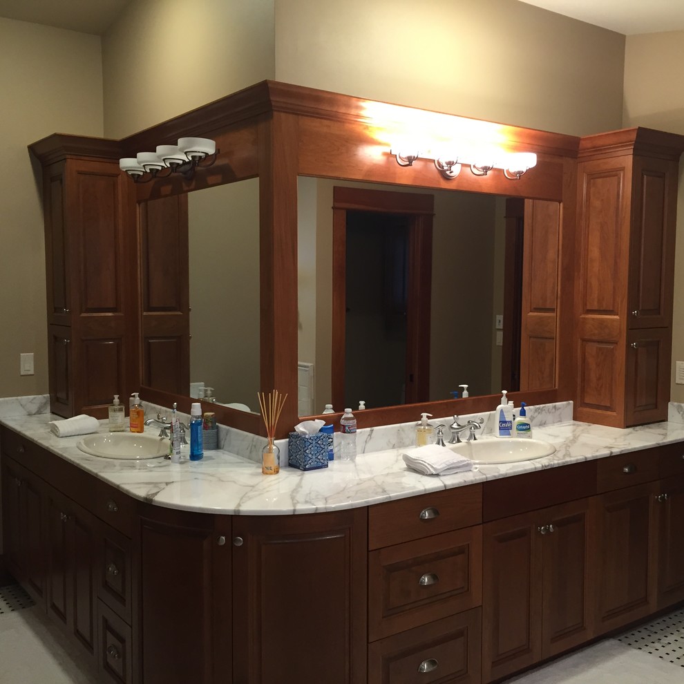Foto de cuarto de baño principal clásico renovado grande con armarios con paneles con relieve, puertas de armario de madera oscura, paredes marrones, lavabo encastrado y encimera de mármol