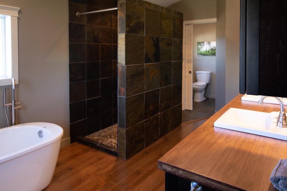 Modernes Badezimmer mit freistehender Badewanne, bodengleicher Dusche, Schieferfliesen und offener Dusche in Calgary