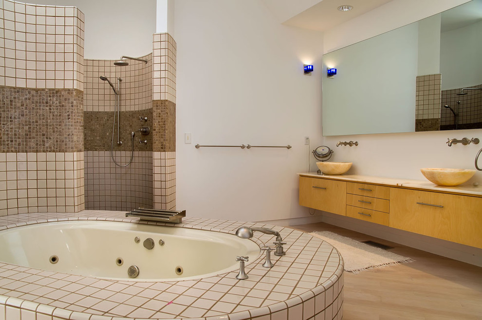 Стильный дизайн: ванная комната в стиле модернизм с настольной раковиной, плоскими фасадами, фасадами цвета дерева среднего тона, полновстраиваемой ванной, открытым душем, бежевой плиткой и открытым душем - последний тренд