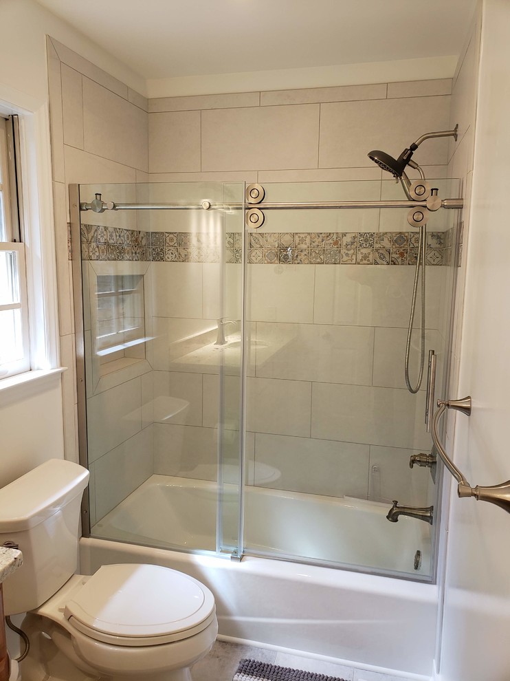 Inspiration for a medium sized classic shower room bathroom in Raleigh with raised-panel cabinets, medium wood cabinets, an alcove bath, a shower/bath combination, a two-piece toilet, white walls, porcelain flooring, a submerged sink, granite worktops, grey floors, a sliding door and multi-coloured worktops.