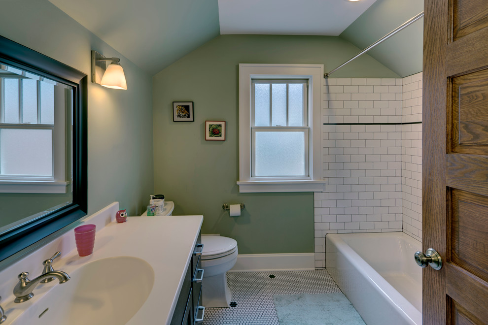 Esempio di una piccola stanza da bagno american style con lavabo integrato, ante lisce, ante in legno bruno, top in superficie solida, vasca ad alcova, WC a due pezzi, piastrelle bianche, piastrelle diamantate, pareti verdi e pavimento con piastrelle a mosaico