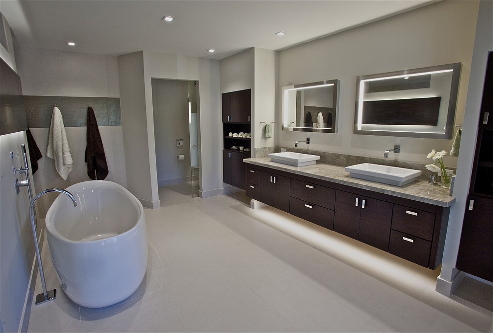 Ejemplo de cuarto de baño contemporáneo con bañera exenta, encimera de granito y lavabo sobreencimera