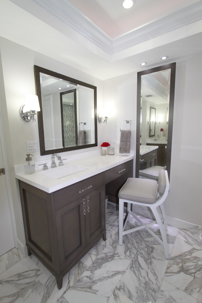 Traditional ensuite bathroom in Miami with a submerged sink, recessed-panel cabinets, grey cabinets, marble worktops, a freestanding bath, an alcove shower, a two-piece toilet, white tiles, grey walls and marble flooring.