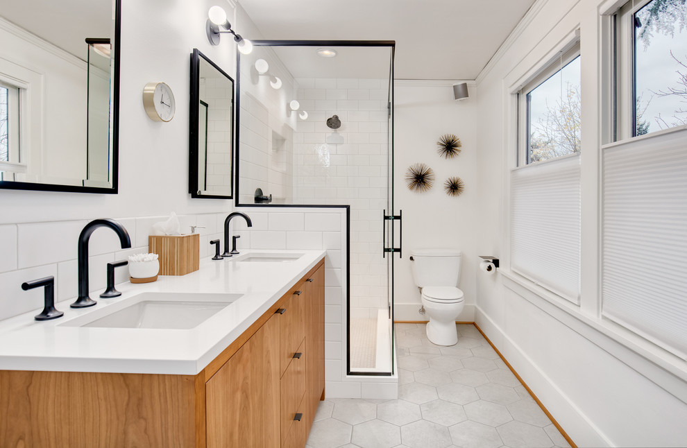 Inspiration for a mid-sized craftsman master white tile and ceramic tile ceramic tile and gray floor alcove shower remodel in Seattle with flat-panel cabinets, light wood cabinets, a two-piece toilet, white walls, a drop-in sink, quartz countertops and a hinged shower door